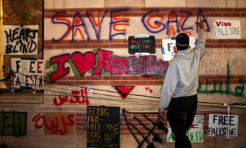 A protester sprays pro-Palestinian slogans on a wall at the University of California Los Angeles