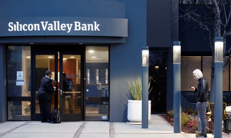 A bank employee waits outside the Silicon Valley Bank headquarters in Santa Clara.