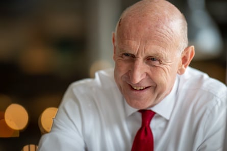 Smiling man in white shirt and red tie.