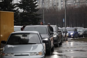 People in cars queue to leave the city of Mariupol in eastern Ukraine