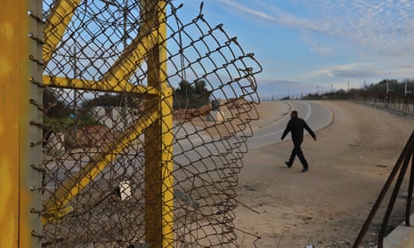 A Palestinian man crosses the broken separating barrier next to the Palestinian village of Shuweika, West Bank.
