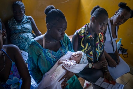 Several seated women, some of whom are pregnant. One holds a baby