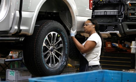 A Ford Motor Company worker works on a Ford F150 truck on the assembly line at the Dearborn Truck Plant