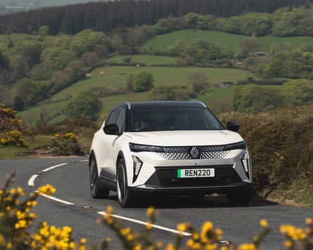 A white Renault Scenic E-Tech driving along a country road