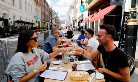 Diners enjoy their drinks as they sit at tables outside a restaurant in London on August 3, 2020, as the Government's "Eat out to Help out" coronavirus scheme to get consumers spending again gets underway. 