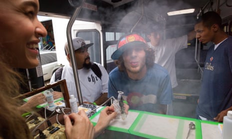 “Dab Dolls” Braylen Thomas, left, and Alex Calahan, left, assist customers in smoking vaproized shatter hash, a butane-extracted canabis oil concentrate.