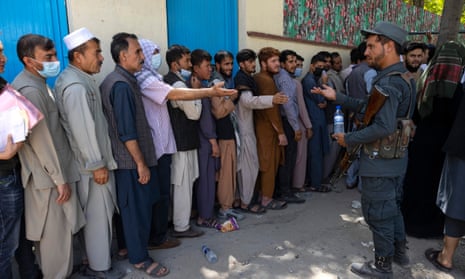 Afghans wait in long lines for hours at the passport office as many are desperate to have their travel documents ready to go on 14 August 2021 in Kabul, Afghanistan.
