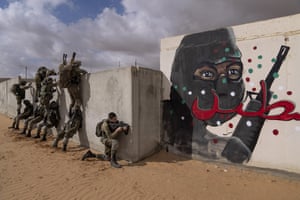 Israeli soldiers scale a wall as they conduct a mock assault during an urban warfare exercise