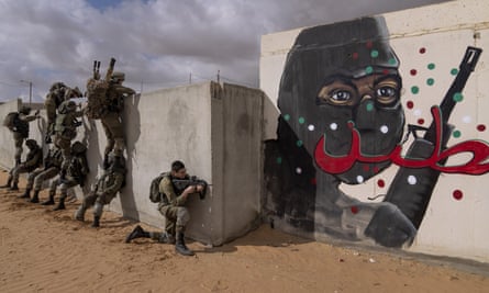 Israeli soldiers climb a wall