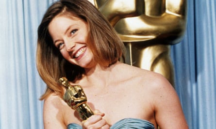 Jodie Foster, smiling, holding her Oscar at the Golden Globes in 1989