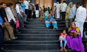 People in Ahmedabad wait for a bank to open so that they can withdraw and deposit money