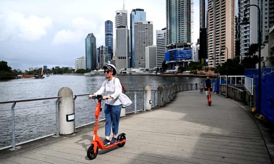 People scooter along the river in Brisbane’s CBD. 