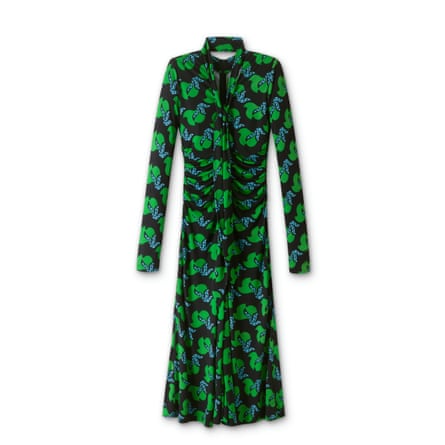 A jersey crepe maxidress with a matching fabric Belt. The dress is navy with a repeating green and blue birds of paradise pattern. There is a long neck tie in matching fabric too. The dress is long-sleeved.