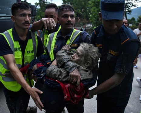 Rescuers carry a survivor in Devghat, in Nepal’s Nuwakot district, after the flash flood