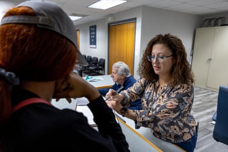 Clinic manager Andrea Gallegos, 40, speaks with a patient at Alamo Women’s Clinic as her father Dr. Alan Braid, 78, sits behind her, in Carbondale, Illinois, U.S., November 3, 2022. In November, Gallegos launched the abortion clinic in Illinois, one of the states that has become a destination for people seeking to end pregnancies because of its protective laws and central location.