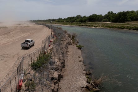 A river with gravel and dirt on the left bank and vegetation on the right bank.