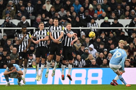 Julian Alvarez hits a free kick as the Newcastle wall jumps