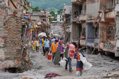 Residents carry their belongings salvaged from their damaged homes