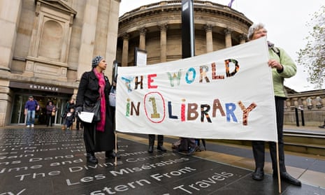 Liverpool central library. People hold a banner that reads the world in one library