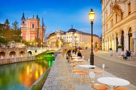 beautiful old town next to a river at evening time with deep blue sky