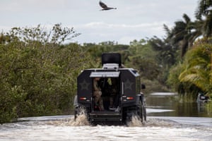 law enforcement drive along a flooded road