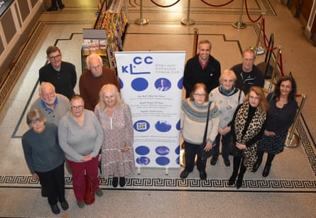 Aerial image of 12 people next to a King’s Lynn Community Cinema Club sign