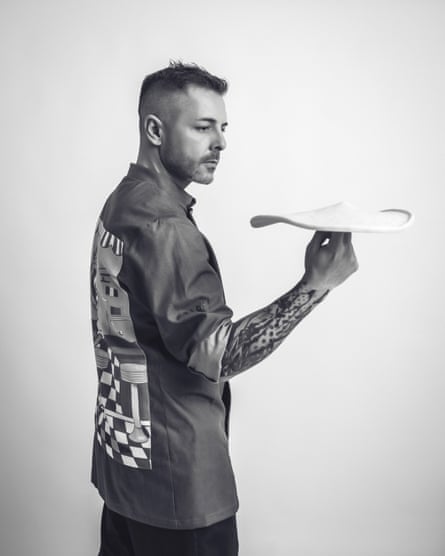 Black and white image of a man spinning pizza dough