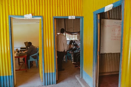 People sit in rooms with colorfully painted walls in yellow and blue.