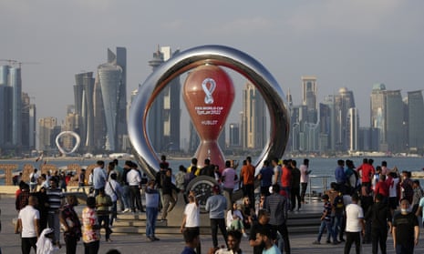People gather around the official countdown clock showing remaining time until the kick-off of the World Cup 2022, in Doha, Qatar