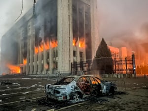 A burnt-out car by the burning mayor’s office on fire. ‘Peacekeeping forces’ from a Russia-led military alliance will be sent to help the country’s president regain control.