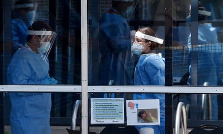 Healthcare workers wait for patients to be tested at a walk-in Covid-19 testing site on 12 May in Arlington, Virginia.