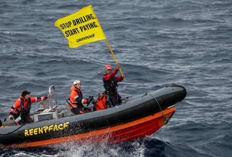Greenpeace executive director, Yeb Saño, holds a flag on a rib after attempting to board a Shell oil platform being transported by the White Marlin ship in the Atlantic Ocean north of Gran Canaria, Spain.