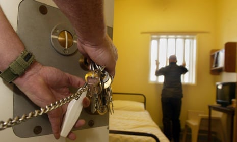 A prisoner officer locking a cell door.