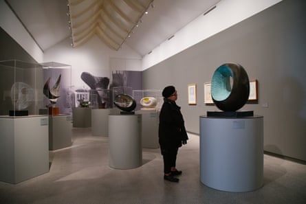 Viewer examines a sculpture in the shape of a large, off-centre ring