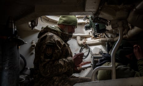 Ukrainian soldier from the 24th mechanised brigade are seen inside an armoured vehicle along the frontline south of Bakhmut.