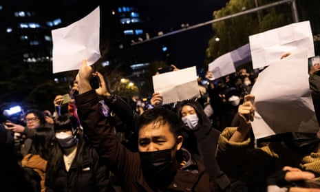 Protesters hold up blank papers and chant slogans as they march in protest in Beijing, Sunday, Nov. 28, 2022.