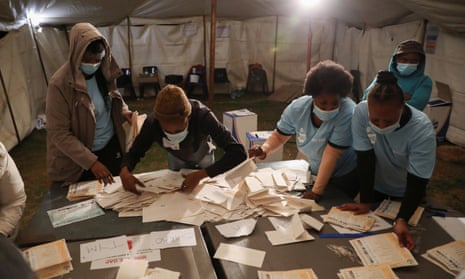 Officials count ballots after the closing of the local government elections, at a farm in Alewynspoort, outside Johannesburg, South Africa.