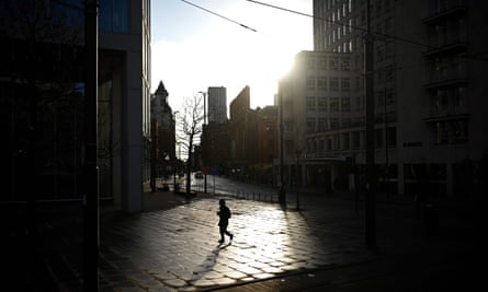 A pedestrian walks in an empty St Peter’s Square in Manchester, north west England on 5 January 2021.