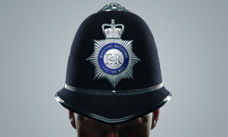 Close-up of police helmet with the words Misogyny, machismo and the Met on the badge