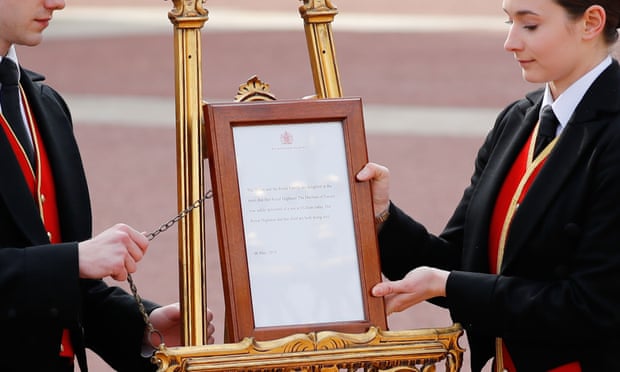 Members of staff set up an official notice on an easel at the gates of Buckingham Palace.