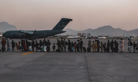 Afghans queue to board a flight out of the country in August 2021