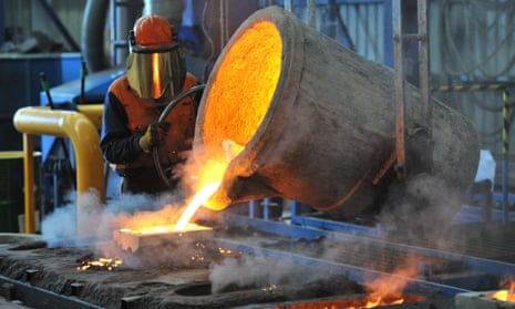 A factory worker pouring molten iron.