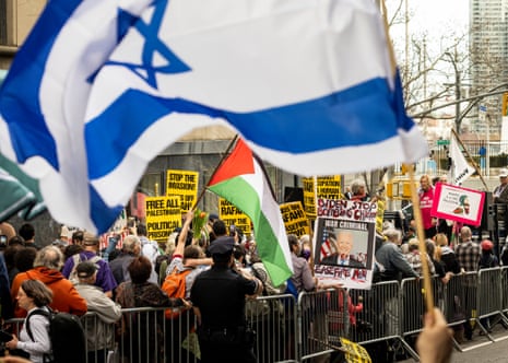 A picture of US president Joe Biden is held by people gathered for a rally calling for a ceasefire in Gaza as pro-Israeli counterprotestors (foreground) wave flags near the UN headquarters in New York on Friday.