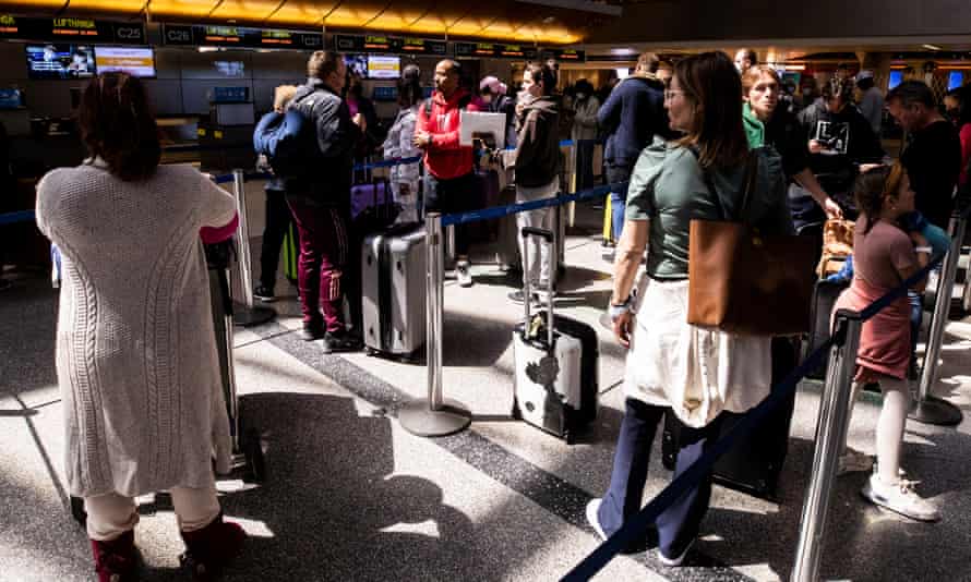 Travelers, mostly unmasked, wait at the international flights terminal of the Los Angeles airport on Tuesday.