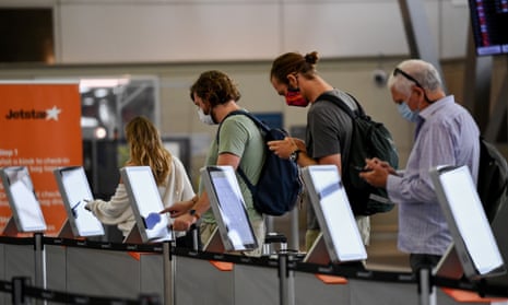 Passengers wear face masks as they check in at the Jetstar terminal at Sydney Domestic Airport in Sydney, 