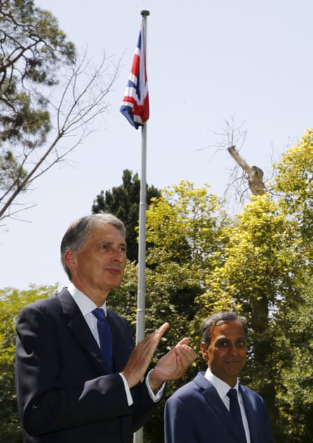 Hammond applauds as the union flag is raised at the embassy.