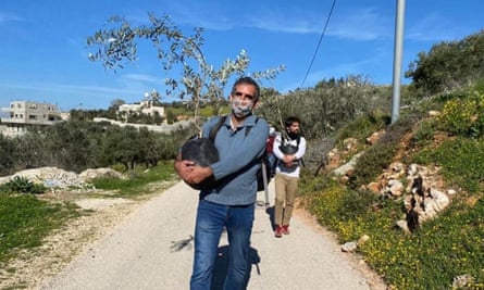 Avi Dabush carrying an olive plant