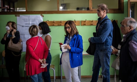 Italians wait in line to casts their ballots at a polling station in Rome.