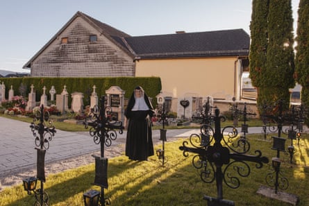 Sister Rita stands on a patch of grass next to a path