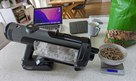 A hand held vacuum cleaner and a bowl of cat treats.